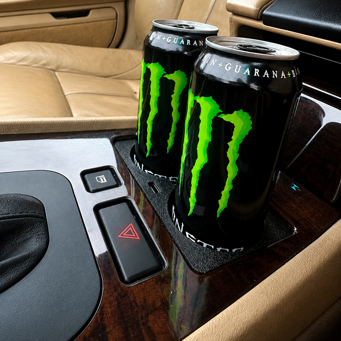 Two cans of Monster energy drink on a car's center console. BMW E38
