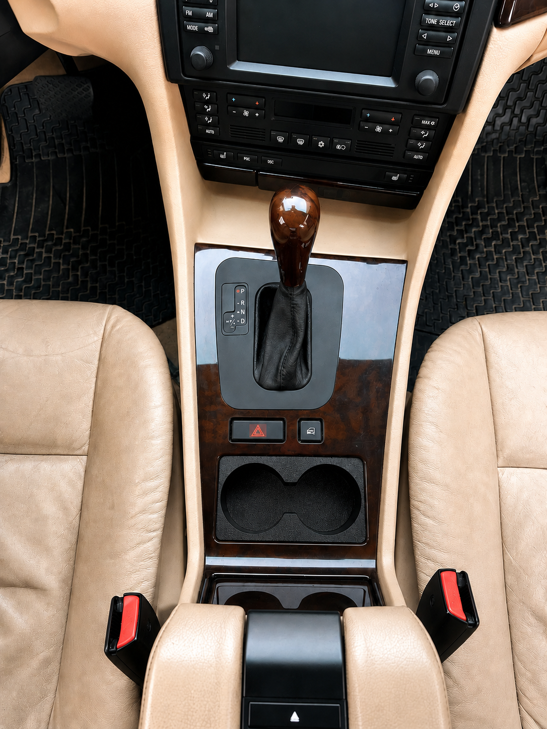 Car interior with beige dashboard, steering wheel, and gear shift.