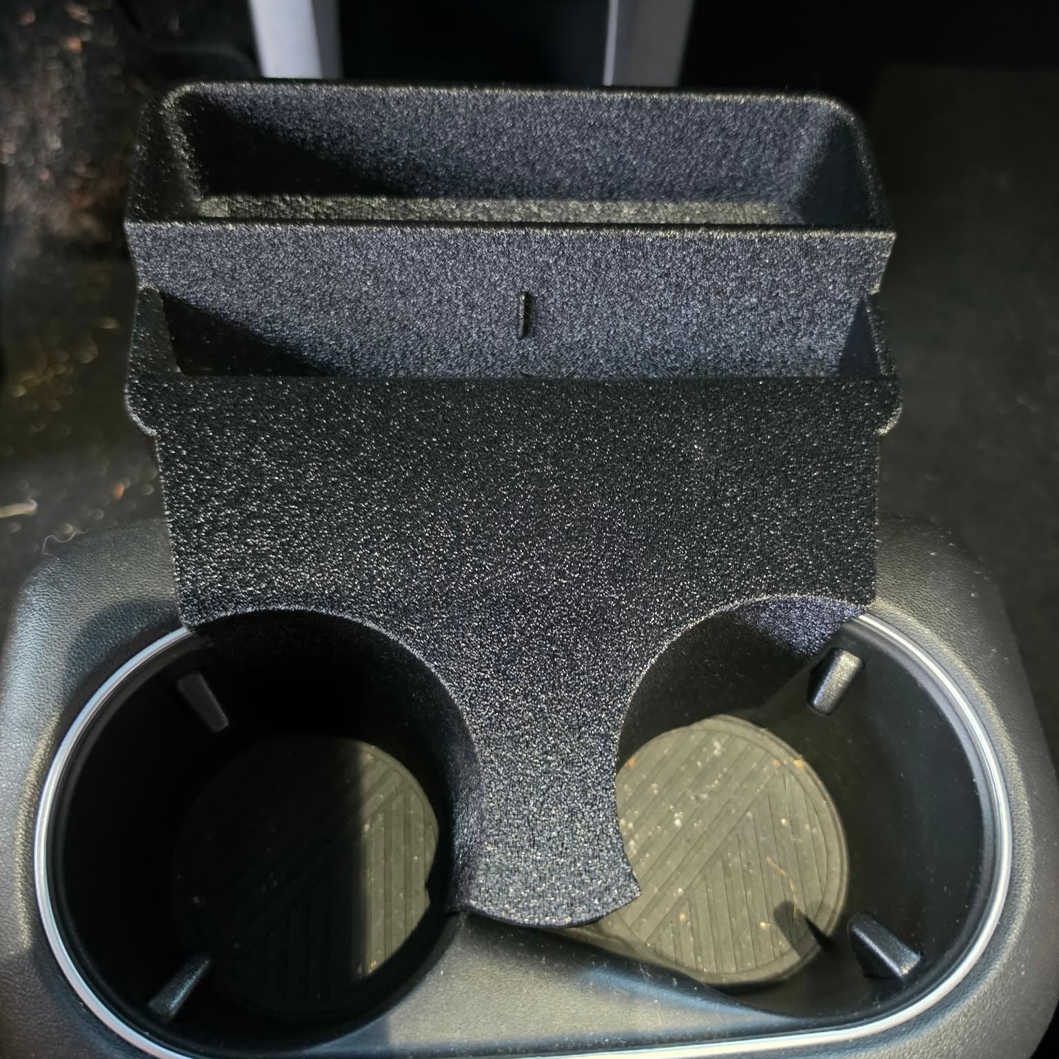 Angled view of Hyundai Ioniq 5 cup holder organizer with phone mounted vertically and storage tray visible